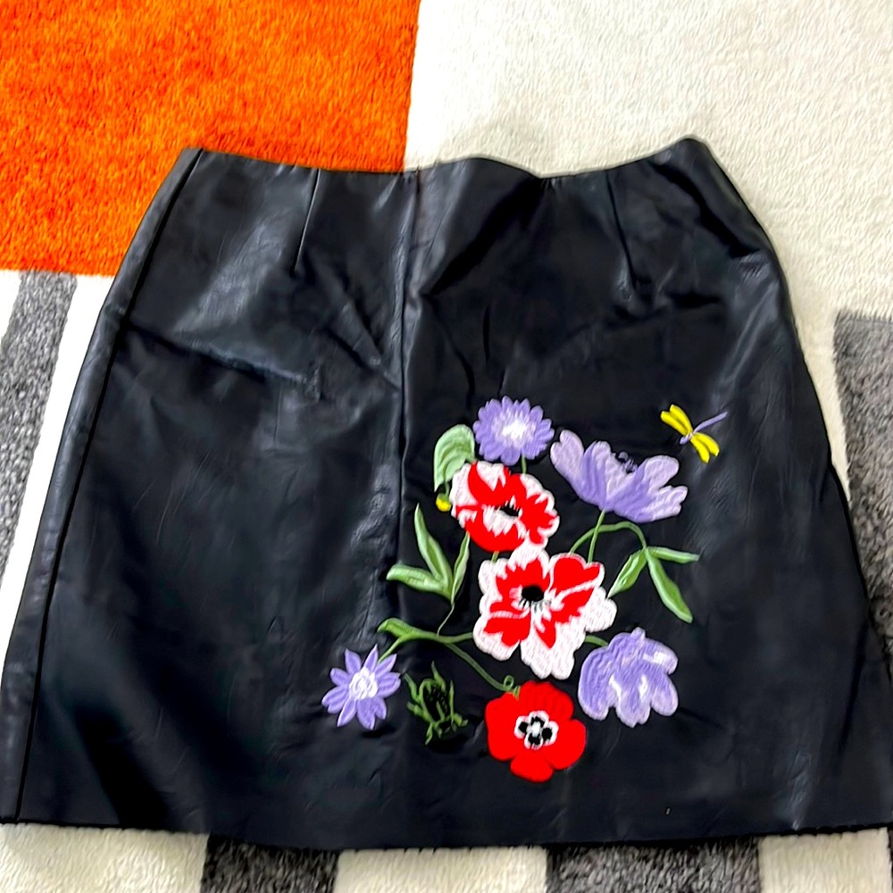 Black faux leather size 6 mini skirt with floral embroidery